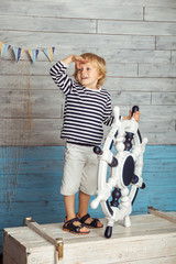 little boy standing with a steering wheel