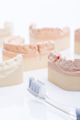 Teeth molds with toothbrush on a bright white table
