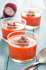 Gazpacho soup in glass on blue wood