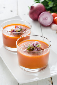 Gazpacho soup and ingredients on white wooden background
