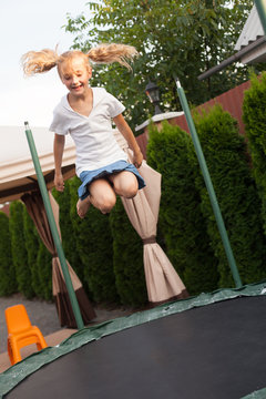Girl is jumping on batut
