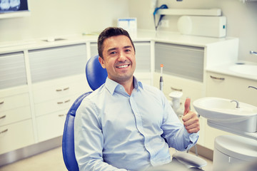 happy man showing thumbs up at dental clinic