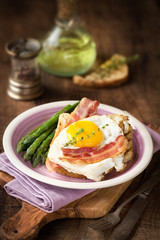 Delicious homemade breakfast with eggs, asparagus stalks, bacon and toast