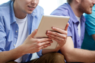 close up of happy friends with tablet pc at home