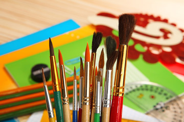 Paint brushes on background of stationery. Selective focus