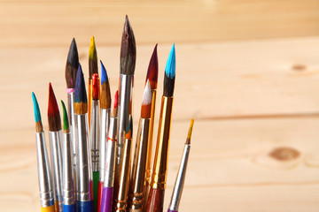 Paint brushes on wooden background. Selective focus