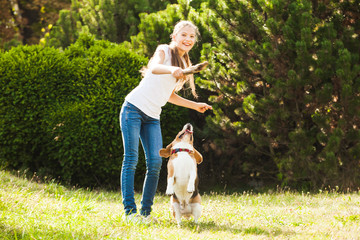 Girl plays with a dog in the yard