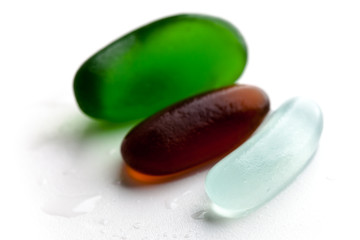 three wet glass pieces polished by the sea