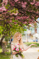 Smiling girl under sakura blossoms