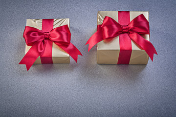 Boxed presents with red bows on grey background holidays concept