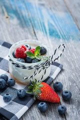Fresh and healthy natural yogurt with berries on wooden table