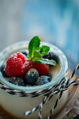 Fresh and healthy natural yogurt with berries on wooden table