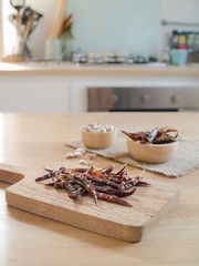 Dried red chili peppers and garlic on wooden board