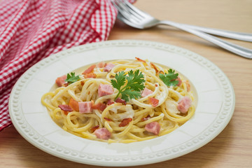 Spaghetti carbonara with ham and bacon on plate