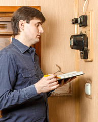 Man takes readings of electricity meters