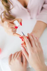 Foto op Canvas Woman in salon receiving manicure by nail beautician © sibstock