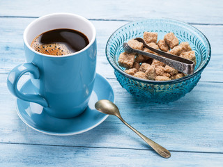 Cup of coffee and cane sugar cubes.