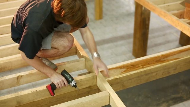 young men skaters build wooden skate park. like carpenters. Young students startup. Skateboarding without money. Builders or joiners