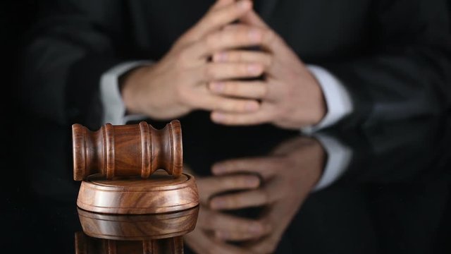 Judge. Referee hammer and a man in judicial robes