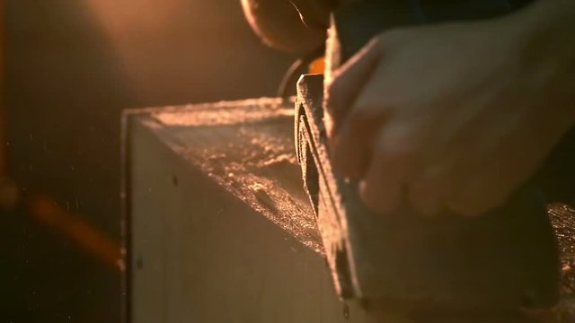 Carpenter polishing wood using electric grinder with polishing extender. close up