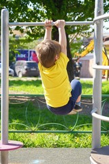 Fototapeta premium Little boy at playground plays sports. Fitness motivation