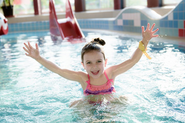 Adorable Little  Girl Enjoying Swimming In A Pool