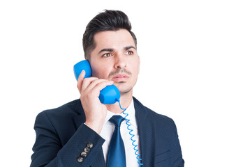 Portrait of serious salesman in closeup dialing on vintage telep
