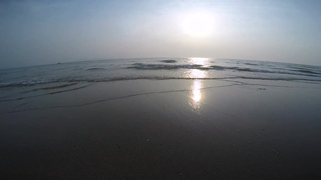 Sunset Over the Ocean with Gentle Waves Using a Wide Fish-eye Lens. Ocean sunset with gentle waves creating a peaceful and tranquil seascape