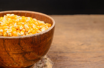 Dried corn seed in wooden bowl on wooden table