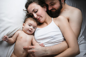 mom, dad and daughter in bed