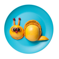 Funny snail made of fruits on plate