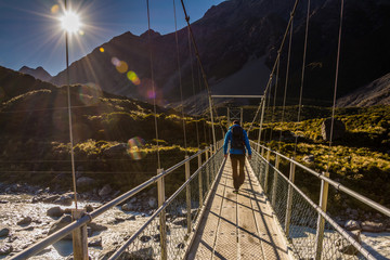 Men crossing a bridge at Mt. Cook in New Zealand 