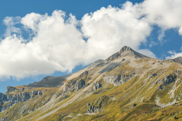 Высокая гора на Кавказе и облака на синем небе