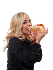 Blond woman eating a sandwich.