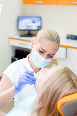 Woman doctor dentist treats a patient