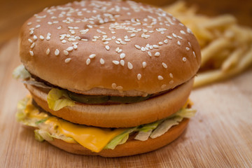 Fast food set big hamburger and french fries on wood background