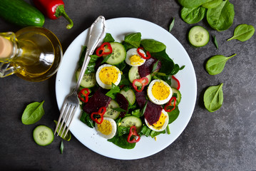Vitamin salad with spinach, egg and beetroot on a black backgrou
