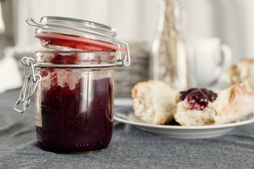 Strawberry marmalade jar with fresh baguette for breakfast.
