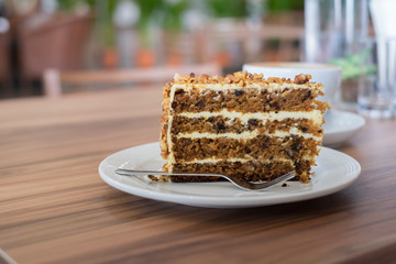 Sliced of carrot cake on white plate on wooden table