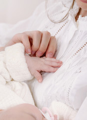 close up mother's hand holding little hand of her baby
