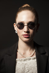 Portrait of Beautiful young woman in sunglasses on black backgro