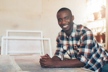 Proud young African business owner in well lit studio space