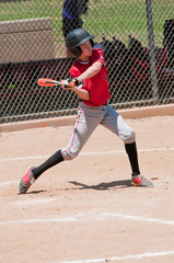 Teenage baseball hitter swinging bat.