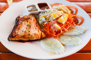 Salmon steak with fresh salad leaf.