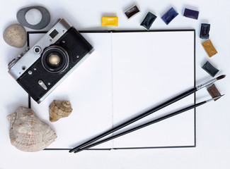 time for creative impressions/Art objects traveling camera, notebook, paint, sea stones and seashells, flat lay, top view
