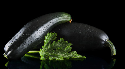 Mature zucchinis on black background