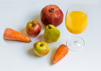 fruit and a glass of fresh juice on a white background