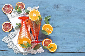 Orange in glass with slice orange on wooden background