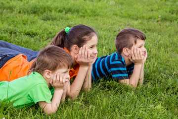 Three kids on green field