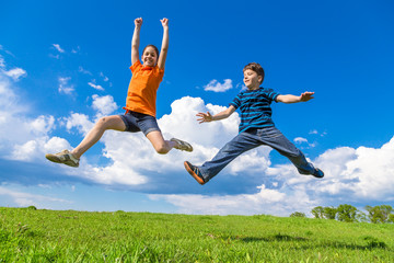 Kids jumping on green hills